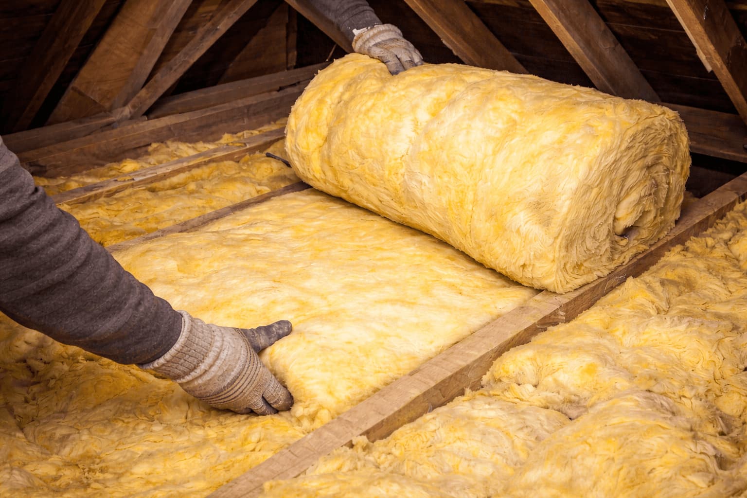An image showing loft insulation being installed in the attic.